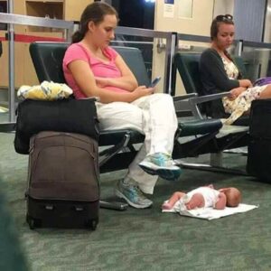 Irresponsible mother..looks at the phone and the baby at her feet