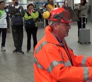 This worker at the train station wows the audience when he starts playing jazz This worker at the train station wows the audience when he starts playing jazz