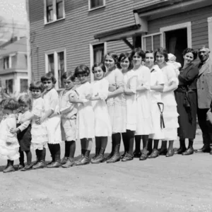 There are as many as thirteen children in this family, all lined up in a row. Now look at the car…